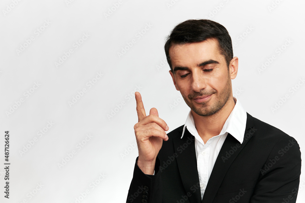 successful manwith closed eyes shows index finger up emotion self-confidence official isolated background successful manwith closed eyes shows index finger up emotion self-confidence official isolated background