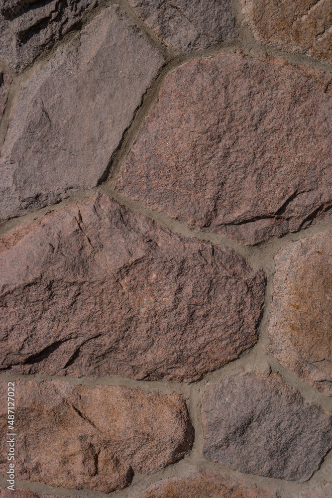 Fototapeta premium Pattern of ancient bricks and stones at old middle age wall, as a background, closeup, details.