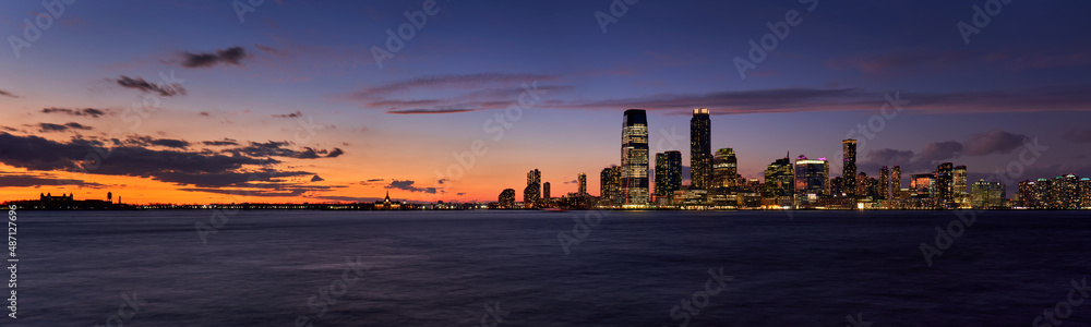 Panoramic view of Downtown Jersey City skyscrapers after Sunset. Riverfront view of the Hudon River at twilight from Ellis Island to Exchange Place to Newport, New Jersey