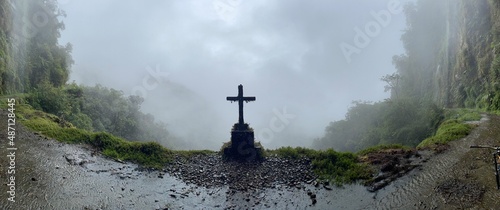 Pan view mysterious grave on the edge of foggy Death Road, Bolivia