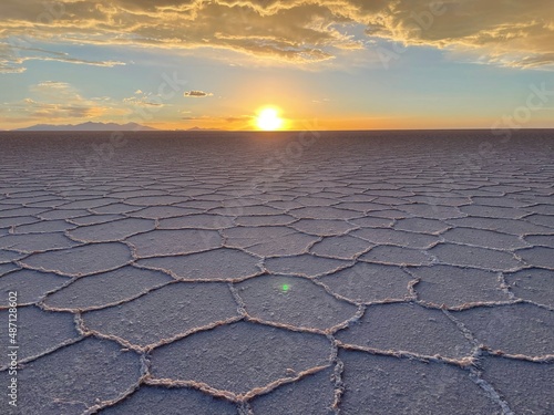 Pan view of landscape with hexagonal salt formations on surface of Salar de Uyuni at dawn, Bolivia