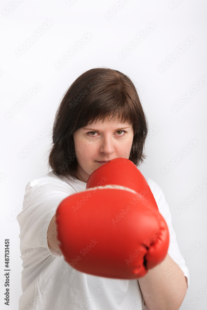 Portrait of confident young woman in boxing gloves. Woman fights for justice. Feminism. Vertical frame Portrait of confident young woman in boxing gloves. Woman fights for justice. Feminism. Vertical frame