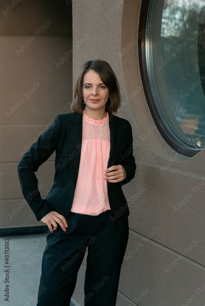 Portrait of successful middle-aged woman in black jacket and pink blouse. Modern successful business woman. Portrait of successful middle-aged woman in black jacket and pink blouse. Modern successful business woman.