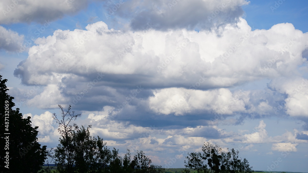 Cumulus (Cu), chmura kłębiasta – oddzielna, nieprzezroczysta, zwykle biała chmura złożona z kropel wody. Jej górna część (z wyjątkiem gatunku Cumulus fractus) ma kształt kopulasty lub kalafiorowaty.  - obrazy, fototapety, plakaty 