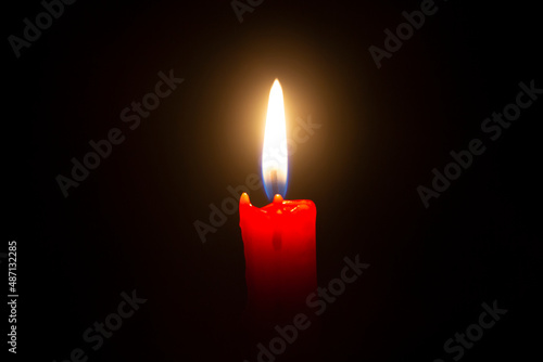 Candle light burns on a black background. Religion 