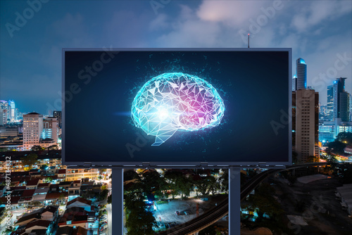 Brain hologram on billboard with Kuala Lumpur cityscape background at night time. Street advertising poster. Front view. KL is the largest science hub in Malaysia, Asia. Coding and high-tech science.