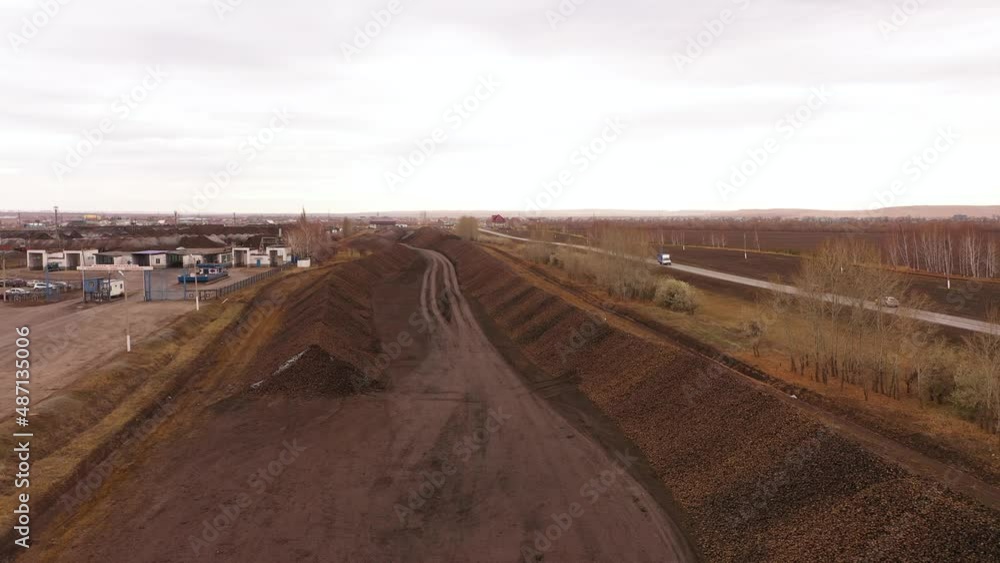 The process of unloading sugar beets. Heap of licorice. The movement of trucks with trailers. Aerial view. The process of unloading sugar beets. Heap of licorice. The movement of trucks with trailers. Aerial view.