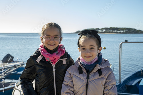 Foto Sorelle gemelle di otto anni al mare in inverno.