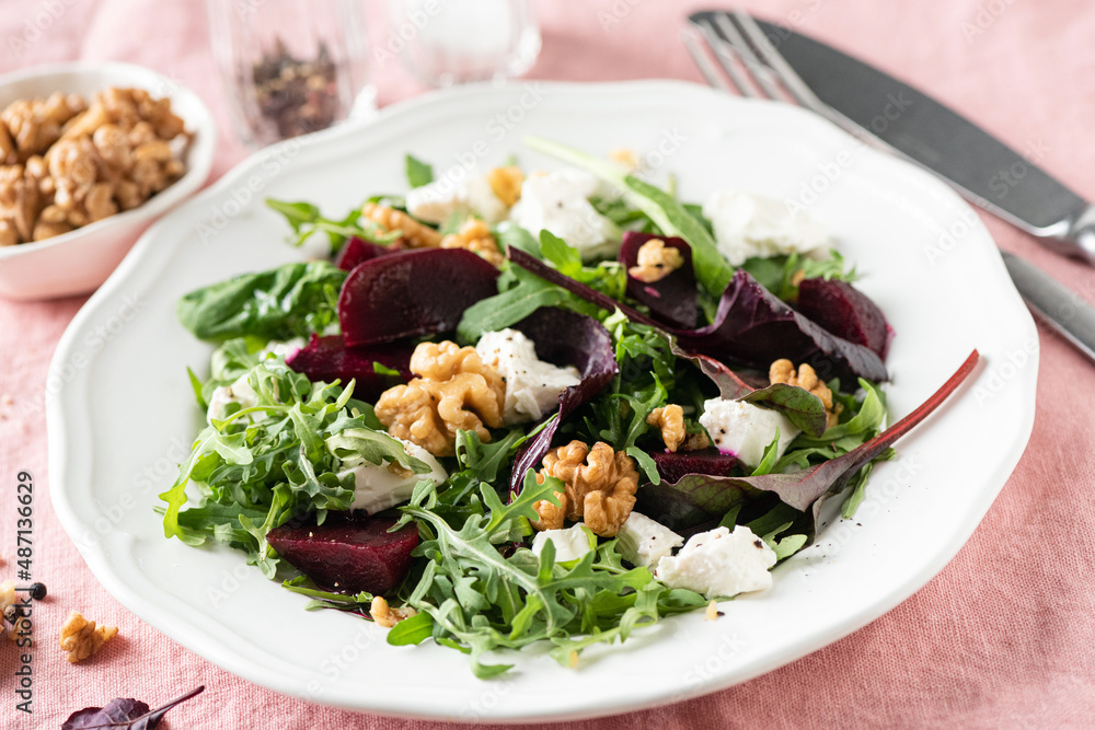 Beetroot salad with goats cheese and walnuts on white plate. closeup view. Diet meal