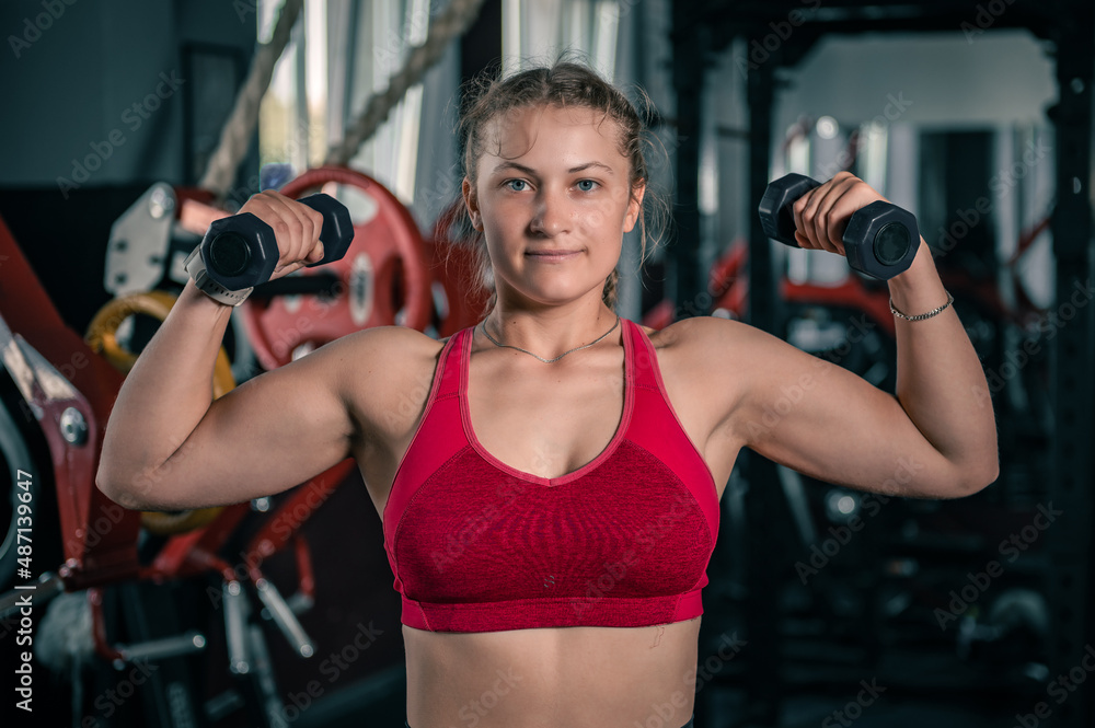 Young woman with dumbbells in the gym. Young woman with dumbbells in the gym.