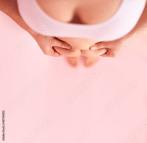 Top view of female legs and a fat female belly on a pink background . Naked big belly