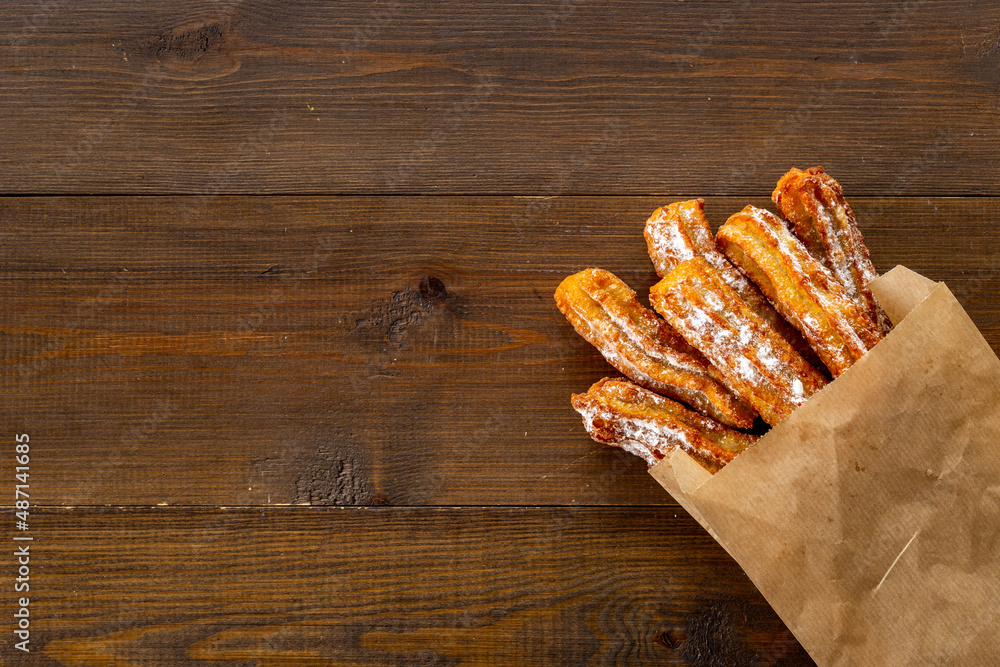 Street food dessert churros in paper bag with sugar Street food dessert churros in paper bag with sugar