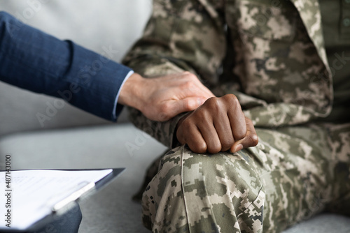 Unrecognizable psychologist comforting military man during session, cropped