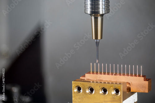 Closeup scene the CNC milling machine cutting the copper electrode parts with solid ball end mill tools.