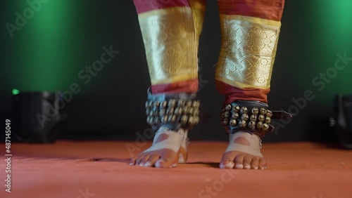 Close up shot of indian bharatanatyam dancer feet with ghungroo kathak or musical anklet dancing on stage - concept of Indian culture, classical dance and traditions photo