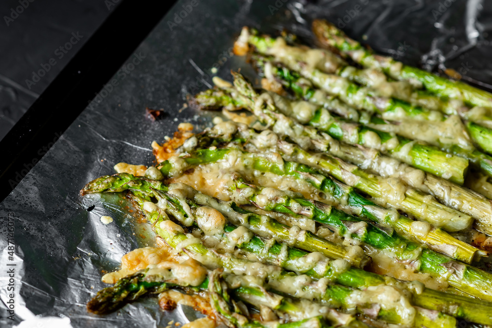 Asparagus baked with cheese on a baking sheet. Vegetarian food. Healthy food. Asparagus baked with cheese on a baking sheet. Vegetarian food. Healthy food.