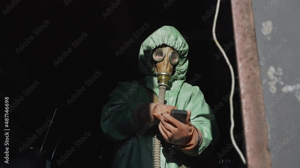 Person in protective costume have radiation control with Geiger counter. Biohazard and air pollution problem. Person in protective costume have radiation control with Geiger counter. Biohazard and air pollution problem.