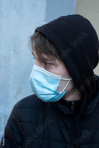 Portrait of young man wearing a medcal mask in outdoor during the covid-19 pandemic photo