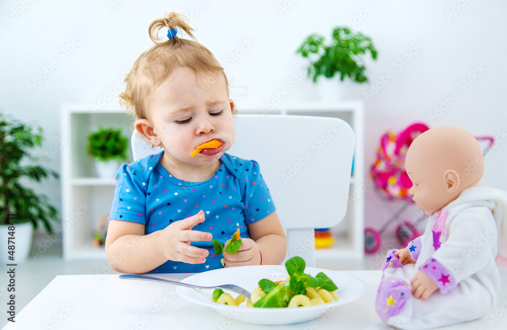 Child baby eats pasta with vegetables. Selective focus. Child baby eats pasta with vegetables. Selective focus.