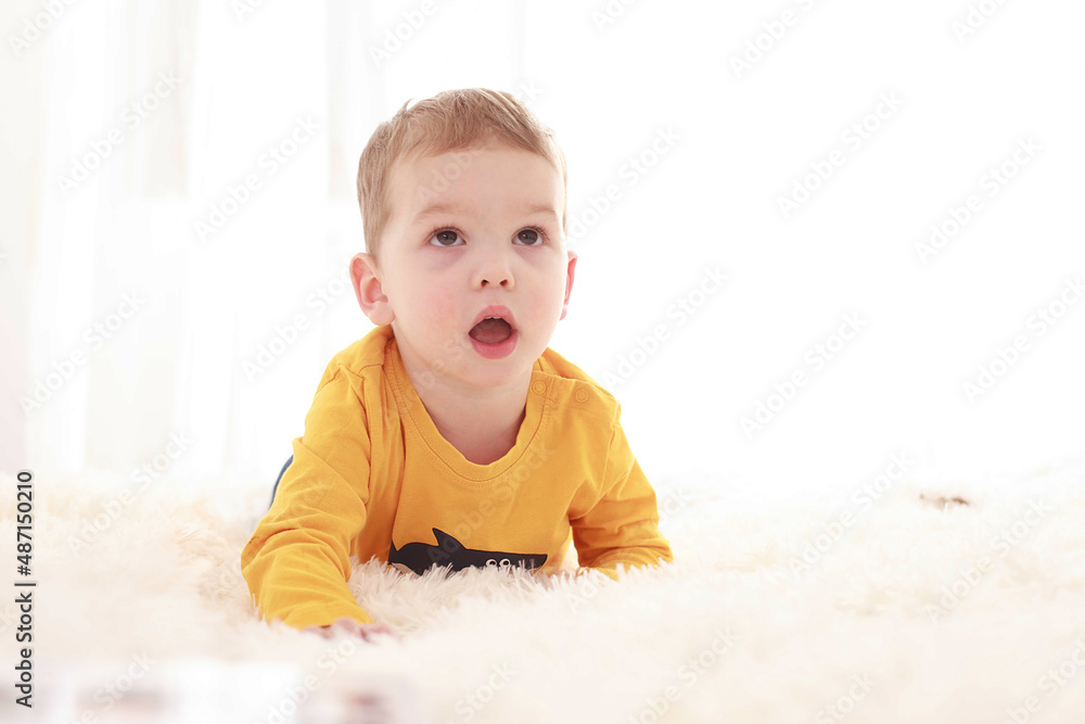 3 year old baby sitting on a white fluffy blanket in a white room and looking around happily
3 year old baby sitting on a white fluffy blanket in a white room and looking around happily