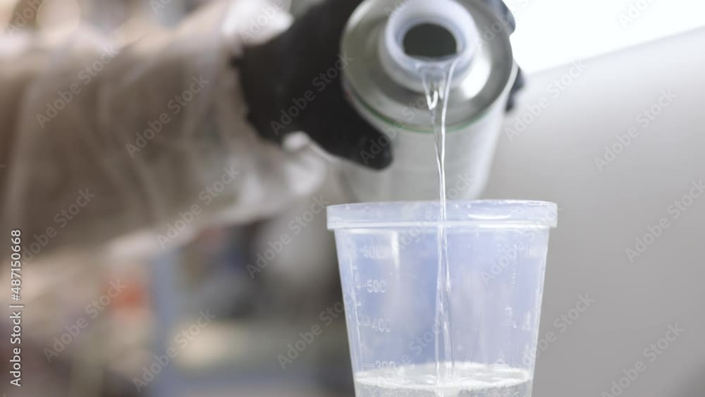 Preparation of varnish for car painting. Industrial car painting process. Varnish for car painting. The painter pours varnish into a container Preparation of varnish for car painting. Industrial car painting process. Varnish for car painting. The painter pours varnish into a container