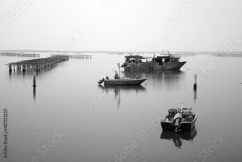 Barche su mare calmo con sfondo allevamenti di vongole presso Chioggia Venezia Italia photo