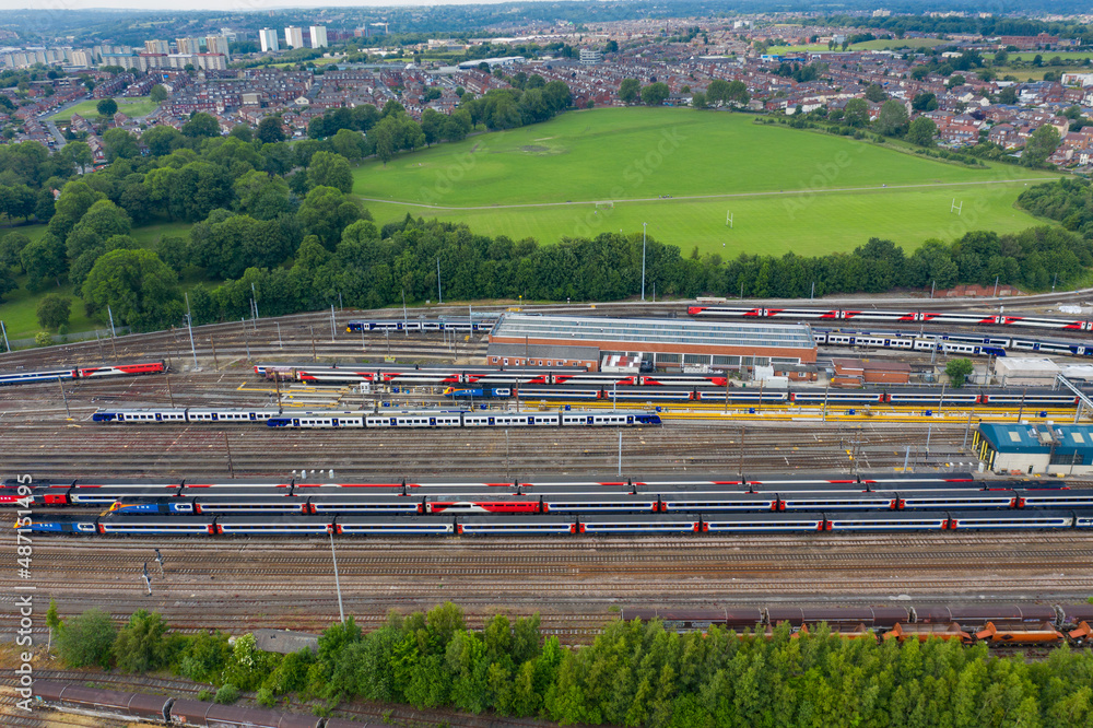 Aerial Photo of a train station works depot with lots of trains in the tracks located in the village of Halton Moor in Leeds, West Yorkshire in the UK on a bright sunny summers day.