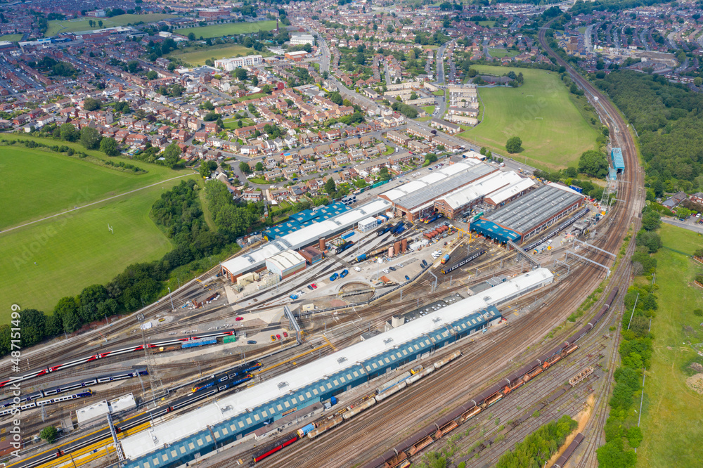 Aerial Photo of a train station works depot with lots of trains in the tracks located in the village of Halton Moor in Leeds, West Yorkshire in the UK on a bright sunny summers day.