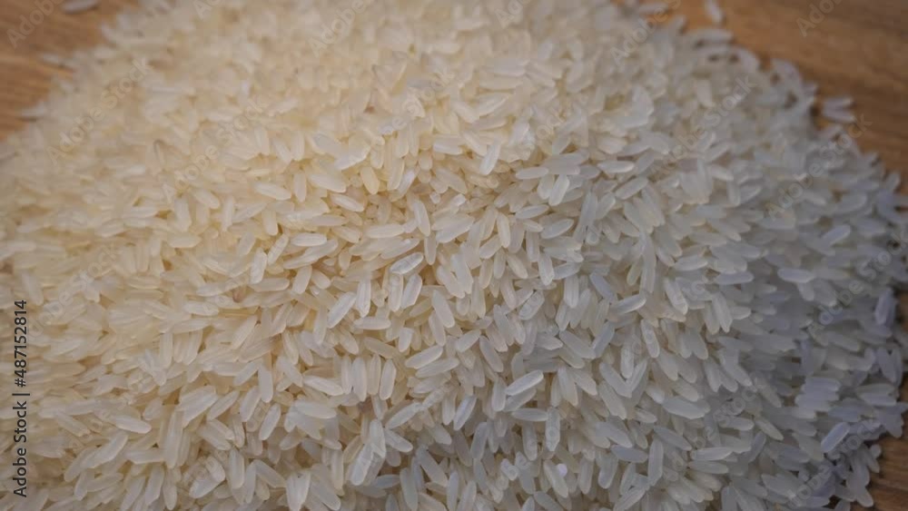 Grains of rice on a rotating wooden surface, top view.
Grains of rice on a rotating wooden surface, top view.