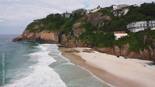 Aerial view of Praia da Joatinga, a paradise in Rio de Janeiro, Brazil. Sunny day with some clouds in the morning. Sea with good waves for surfers. Greenish sea. Drone take.
