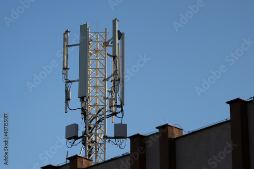 Telecommunication tower of 4G and 5G cellular. 5G radio network telecommunication equipment with radio modules and smart antennas mounted on a metal. Blue sky in the background. Located on the roof.