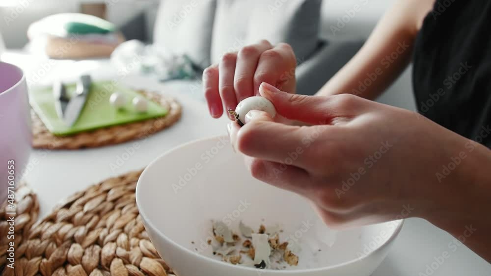 A young girl peels quail eggs from the shell A young girl peels quail eggs from the shell
