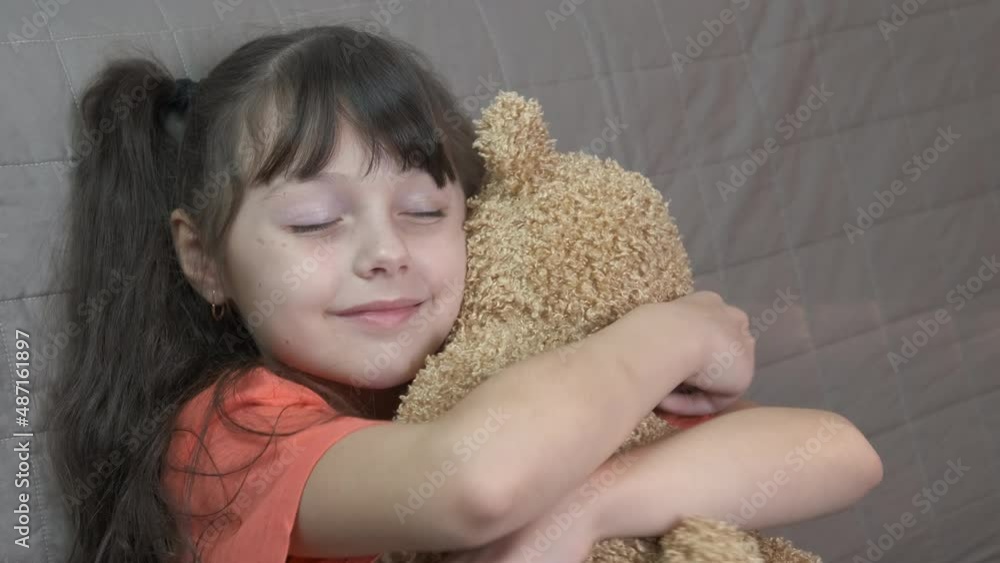 Plush toy in child hands. A view of plush toy in warm little girl hands in the room.