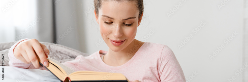 Young white woman reading book studying