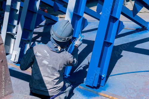 The painter uses a spray gun to paint a steel structure before transportation to the assembly yard.