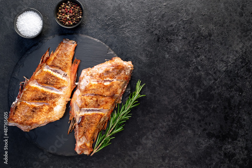 grilled red sea bass with rosemary and spices on a stone background  with copy space for your text