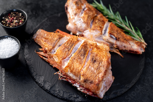 grilled red sea bass with rosemary and spices on a stone background  © александр таланцев