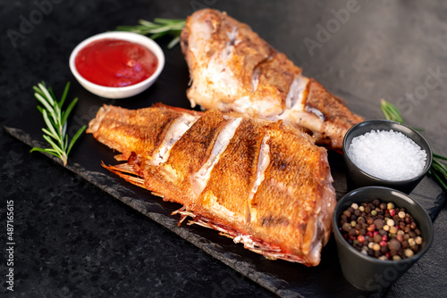 grilled red sea bass with rosemary and spices on a stone background 