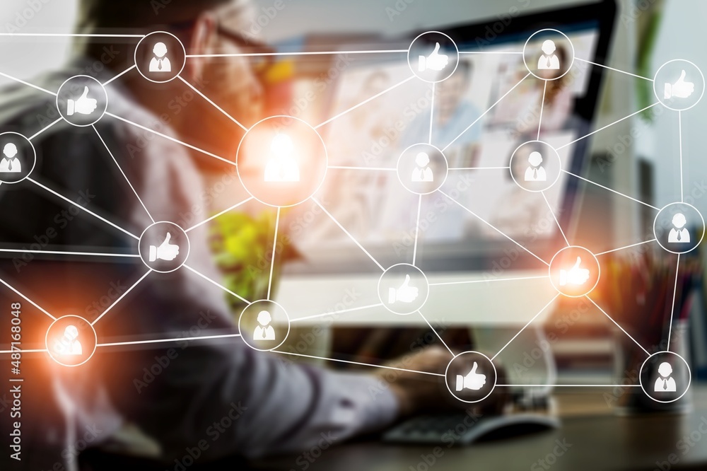 A serious caucasian manager in casual wears, using laptop to develop a new network. Social media hologram.