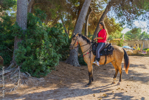 Young woman riding a horse on a ranch