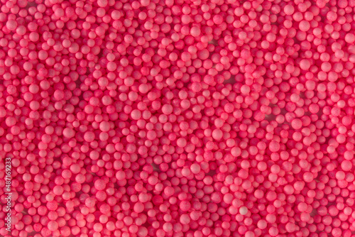 Many pink little balls for children playground. Cosmetics powder. Candy sprinkles. Top view. Trendy absract background or backplate for your design