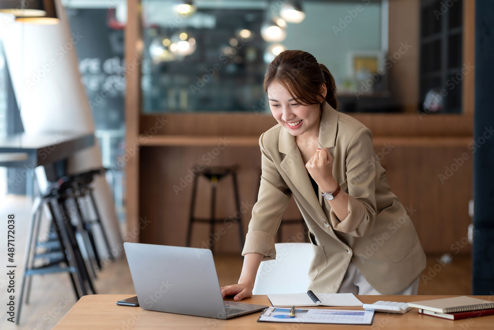 Happy Asian Businesswoman Standing Successful Excited Raised Hands Rejoicing With Laptop Computer At Office. Happy Asian Businesswoman Standing Successful Excited Raised Hands Rejoicing With Laptop Computer At Office.