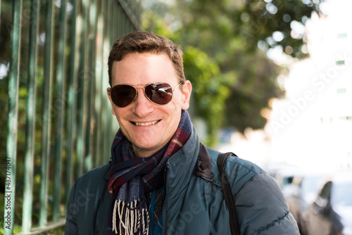 trait of a confident 40 year old white man with a scarf and sunglasses