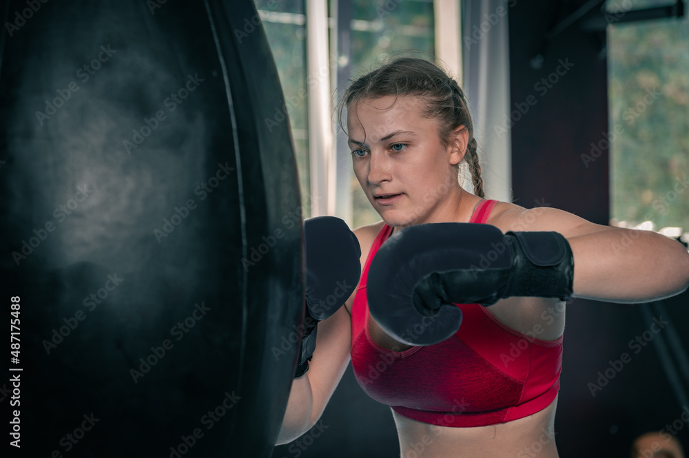 Woman boxing with punching bag