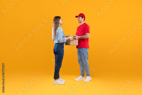 Courier Guy Giving Cardboard Parcel Boxes To Lady, Yellow Background