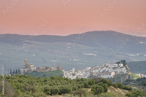 View of the Cordovan town of Iznájar (Spain) on a hill between olive groves photo