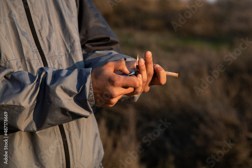 Close-up of the hands of a young boy holding a marijuana cigarette