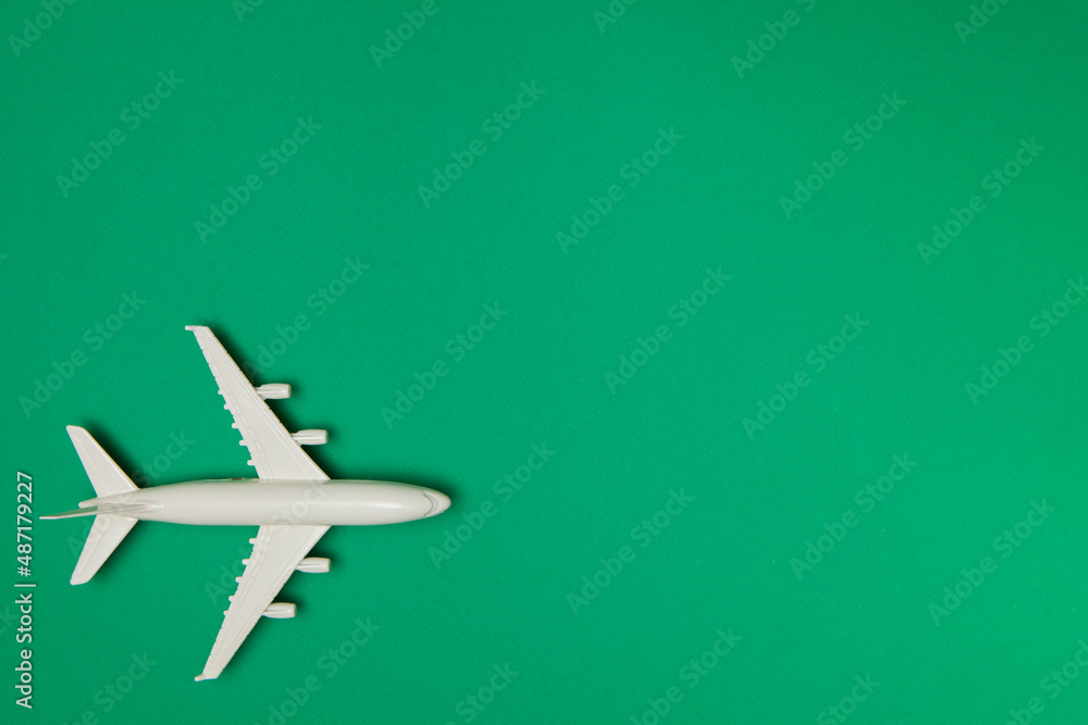 Fototapeta premium Airplane model. White plane on green background. Travel vacation concept. Summer background. Flat lay.