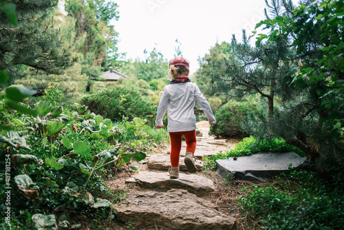 Young child walking on stepping stones in a park photo