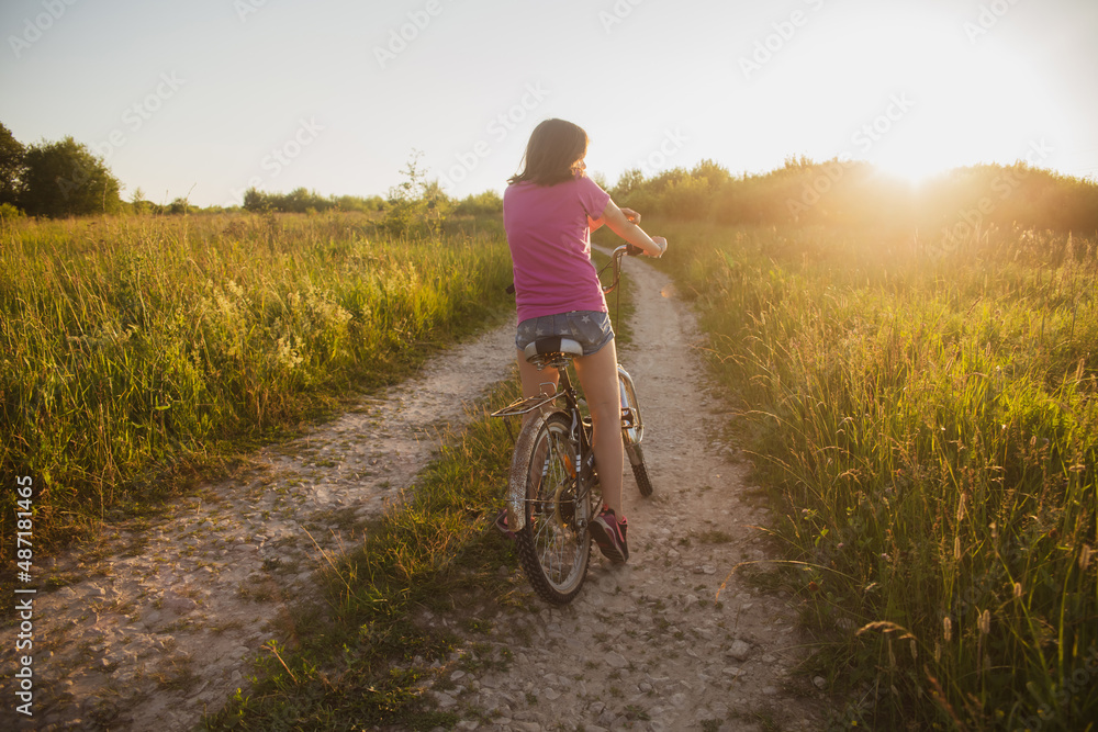 Teenage girl on an old bike in the field Teenage girl on an old bike in the field